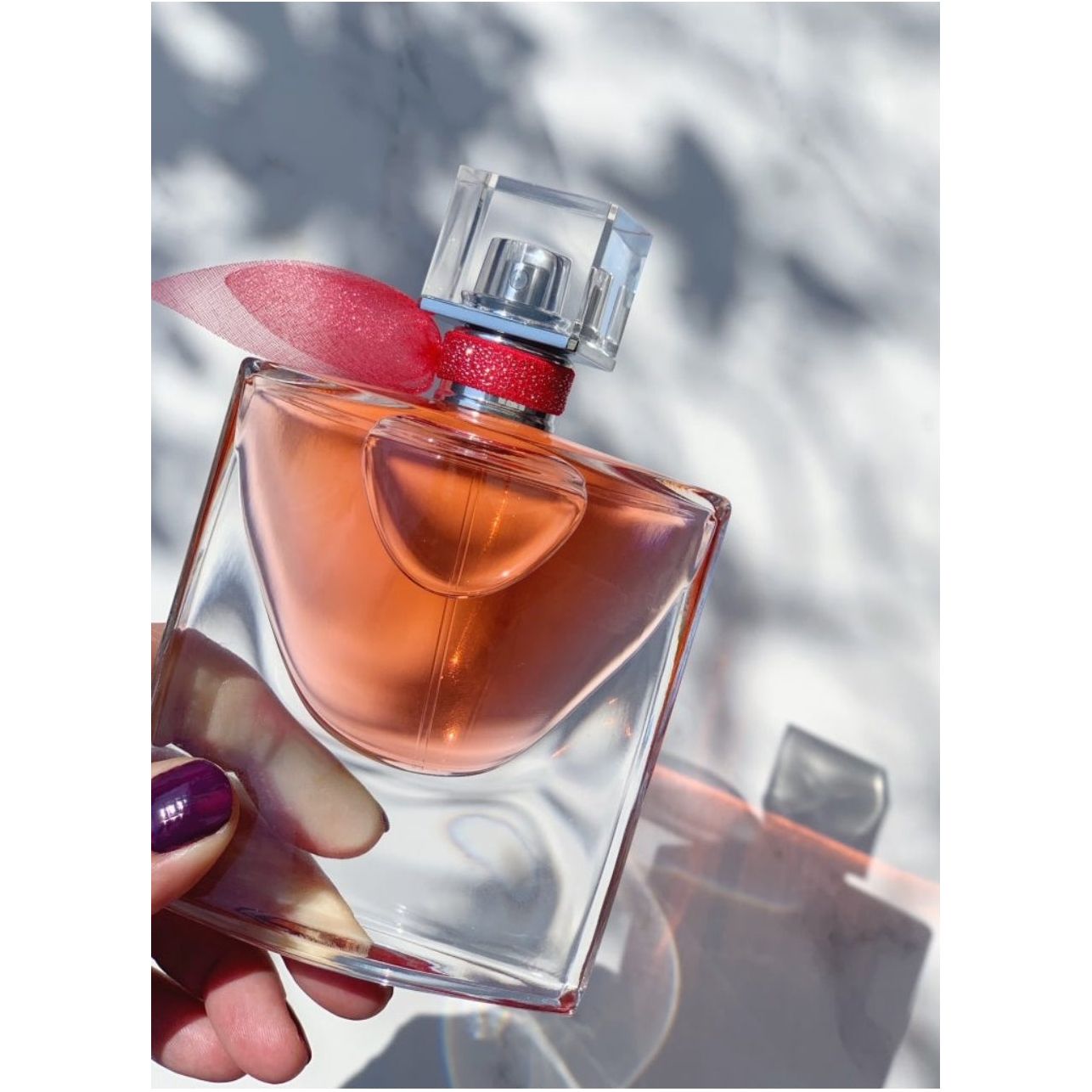 Stylish perfume bottle with pink ribbon, capturing elegance for signature scents at HAUTE SPOT.
